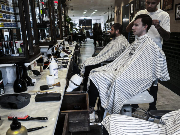 Barber scheert een klant bij Hairjockey Barbers Breda